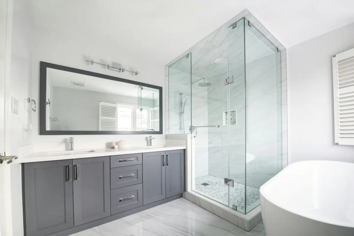 Salle de bain claire avec douche vitrée et meuble double vasque