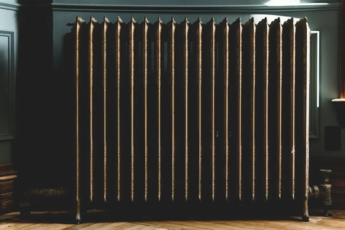 Radiateur en fonte rénové dans une pièce aux murs sombres