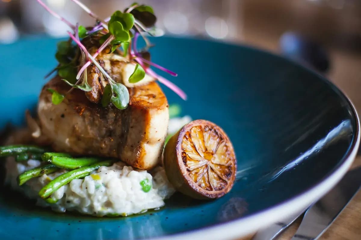 Poisson rôti sur un risotto aux herbes, citron grillé